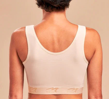 Woman wearing beige post-surgical Marena bra, back view, against neutral background